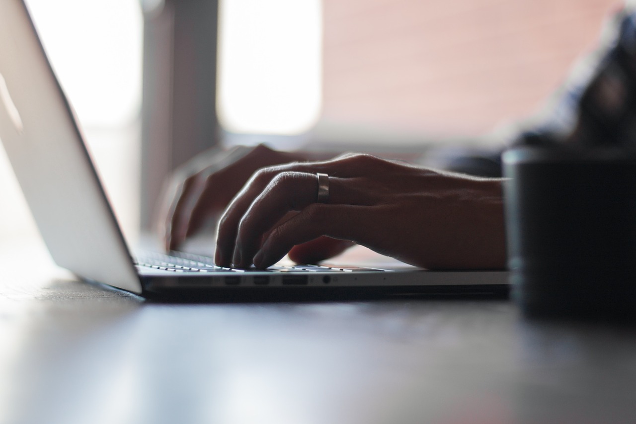 man with ring on typing