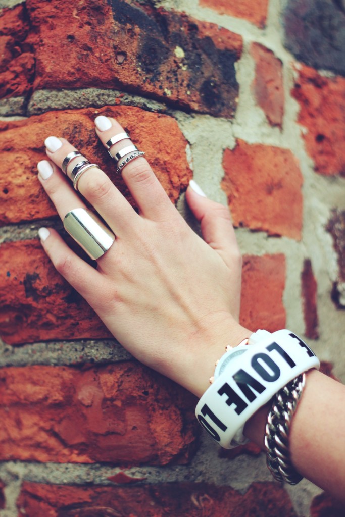 A woman's hand adorn with many different types of rings.